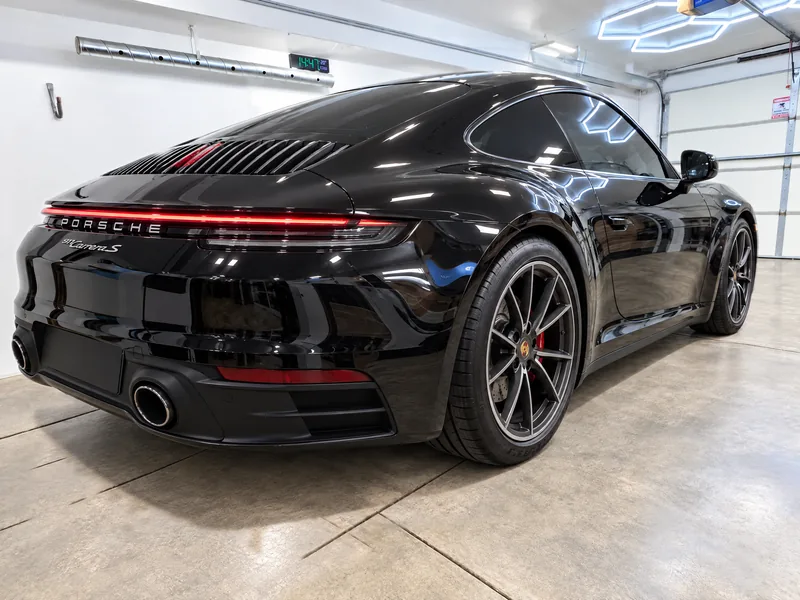 A black Porsche 911 with ceramic window tint parked in the Beast Auto Tints bay in Chicago
