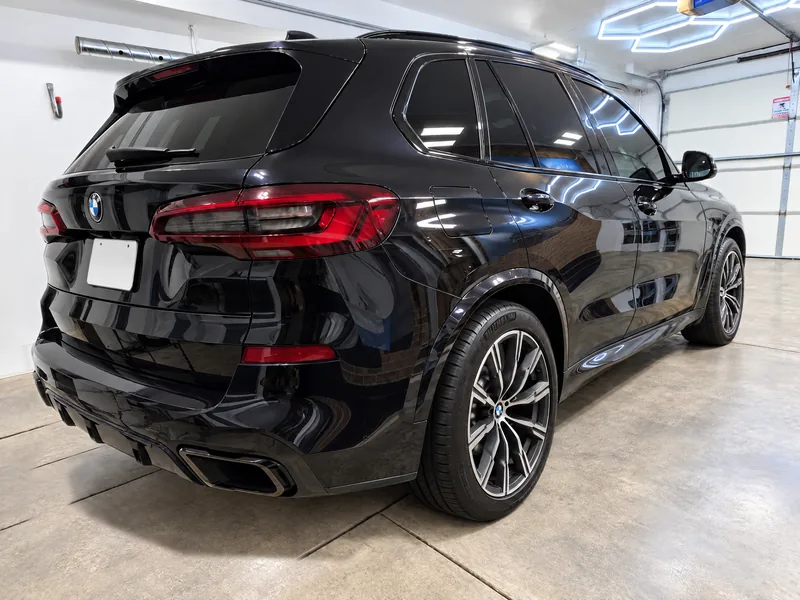 A black BMW X5 with tinted windows parked in the Beast Auto Tints bay in Chicago
