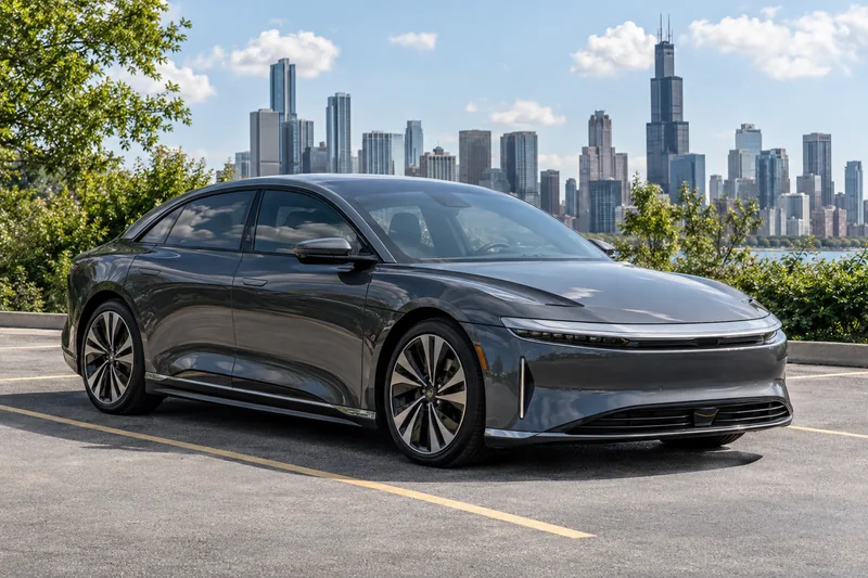 A gray Lucid Air with light ceramic tint in bright sun by the Chicago skyline