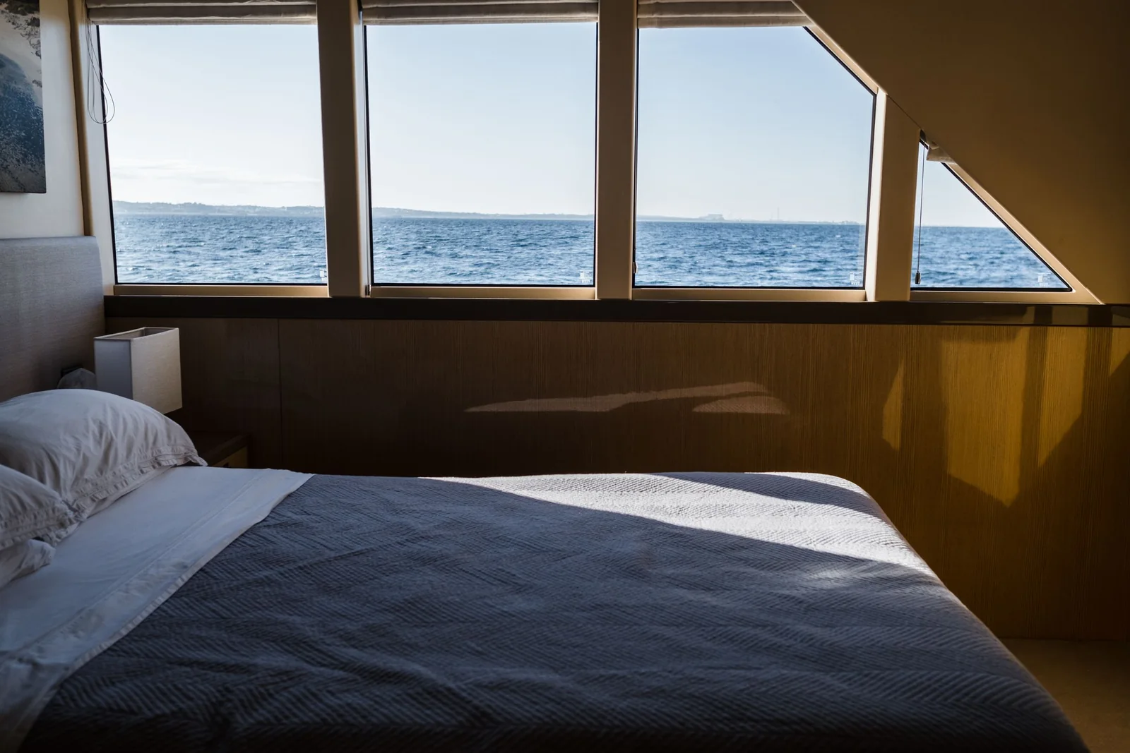 Bedroom with large windows looking out over the water