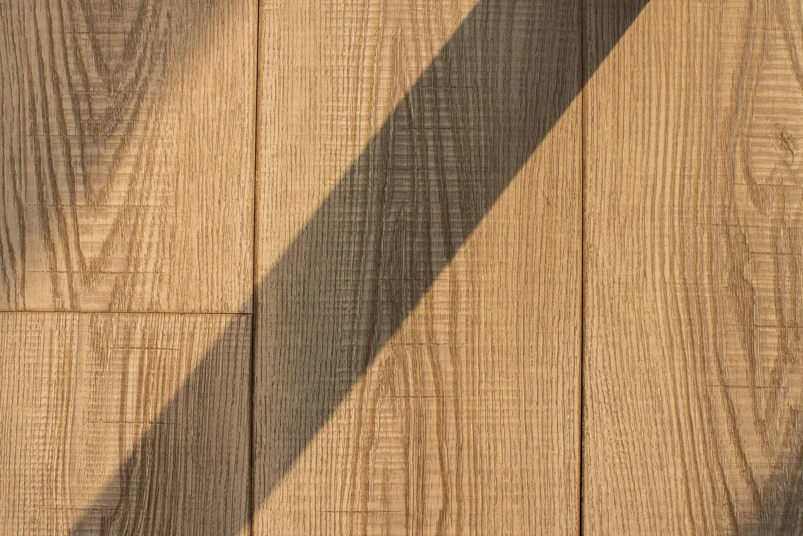 Sunlight and shadow across a wooden floor