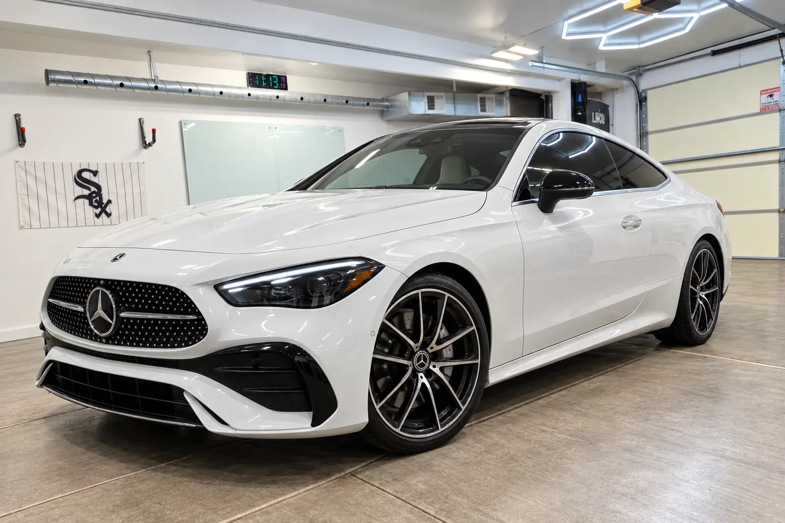 Pearl white Mercedes-Benz CLE coupe with tinted windows inside the Beast Auto Tints workspace in Chicago